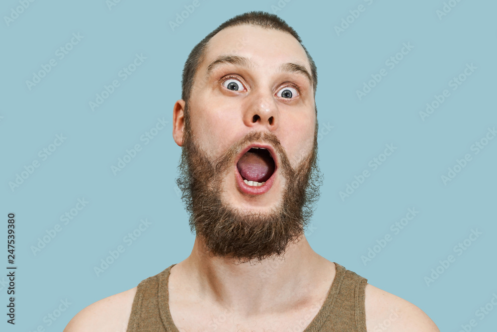 Very surprised scared funny face of a bearded guy with open mouth and big  eyes on an isolated background Stock Photo | Adobe Stock