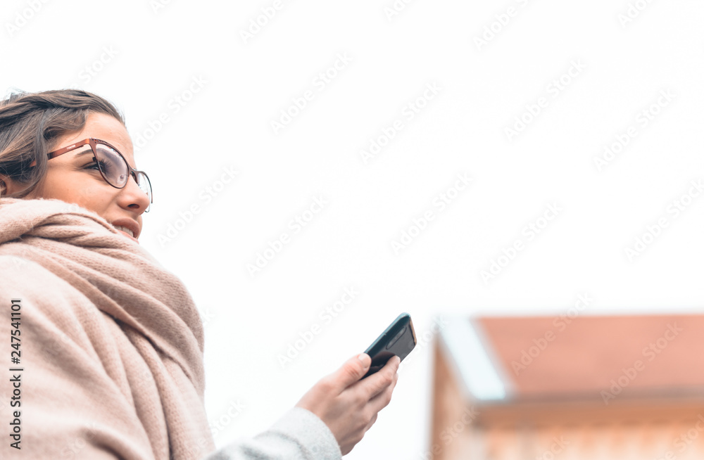 Beautiful young woman using cell phone app to find her way through the city Beautiful young woman using cell phone app to find her way through the city