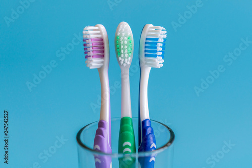 Toothbrushes on blue background. Flat lay composition with manual toothbrushes on color background, close up.