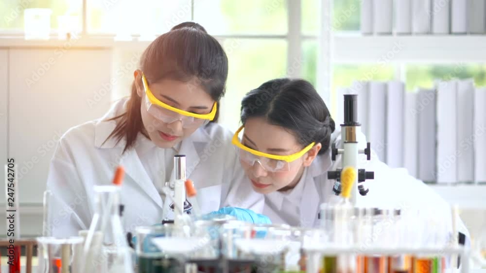 Female scientists are taking a laparoscopy to see some test results at the laboratory. Female scientists are taking a laparoscopy to see some test results at the laboratory.
