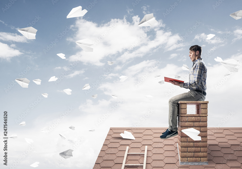 Handsome student guy reading book and paper planes flying in air Handsome student guy reading book and paper planes flying in air