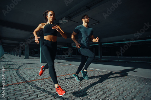 Young sports couple running in the urban environment