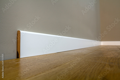 Canvas Print Wooden or plastic white floor plinth installation in big empty room on wooden floor and white plastered stucco walls background