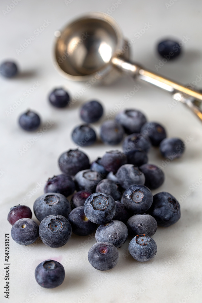 Frozen blueberries scattered on marble base Frozen blueberries scattered on marble base