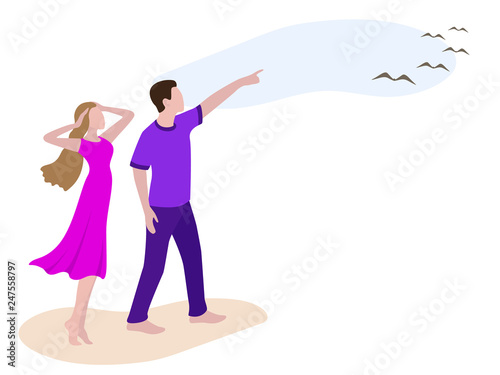 Young man showing to girl birds in the sky. Romantic couple walking on the beach. Man and woman on the walk looking up in sky. Boy and girl in casual clothes: purple female dress, violet male t shirt