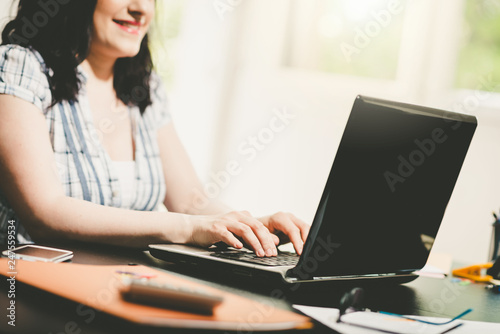Young attractive businesswoman working on laptop, light effect