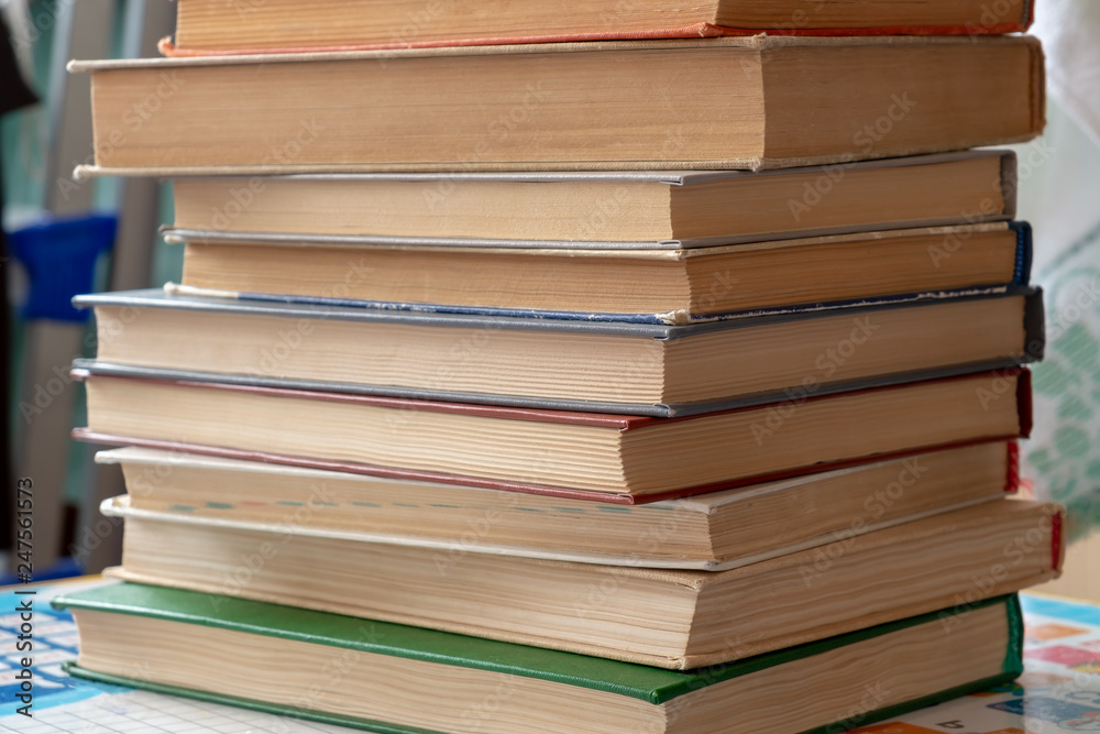 On the table is a stack of books with yellowed paper. On the table is a stack of books with yellowed paper.