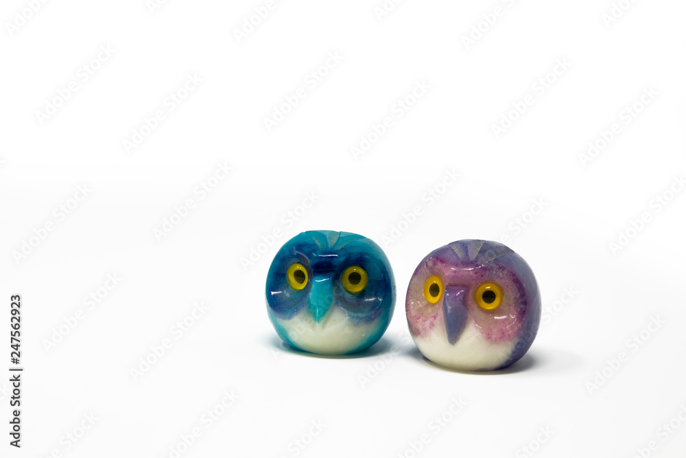 Obraz premium Lucky owl ornament. Small glass lucky object, charm. Blu, azzurro, lilla, viola, giallo. Isolated on white background. Tradition has it that a pair (couple) of owls bring luck.