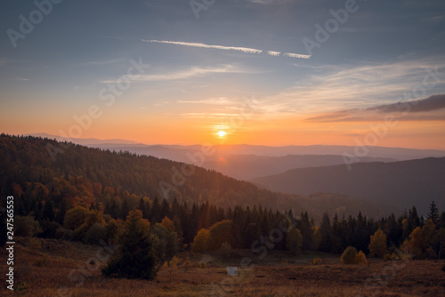 beautiful scenic autumn mountain landscape with colorful forest on sunset. Mountains in mist