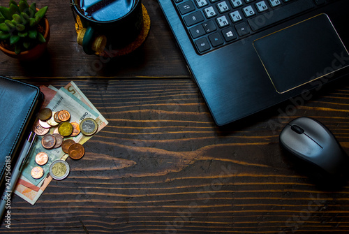 laptop and money on the wooden table