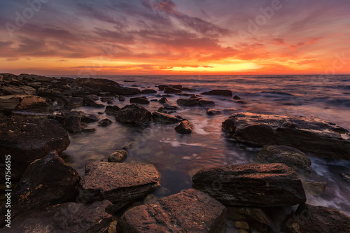 Sea sunrise at the rocky beach. Amazing view with rocky beach seascape at sunrise.