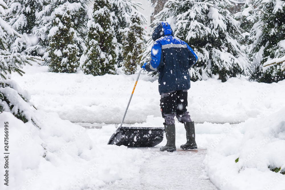 Man removing snow from the sidewalk after snowstorm. Man removing snow from the sidewalk after snowstorm.