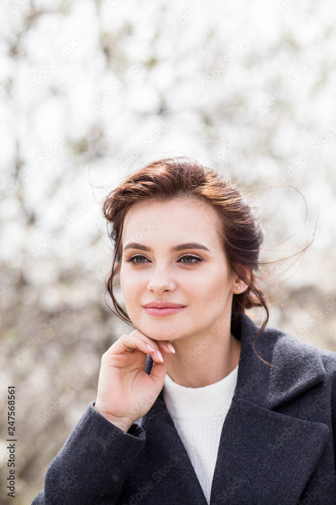 Beautiful young woman with dark hair in wool coat outdoor. Spring time tenderness. Beautiful young woman with dark hair in wool coat outdoor. Spring time tenderness.