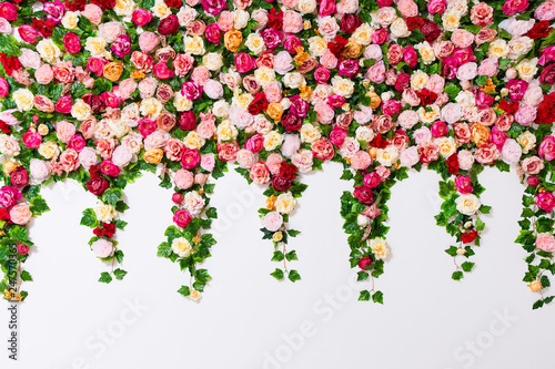 spring and summer background - close up of colorful composition with artificial flowers over white wall