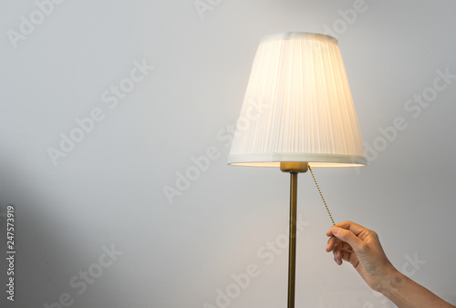 Female hand switch on table lamp.
