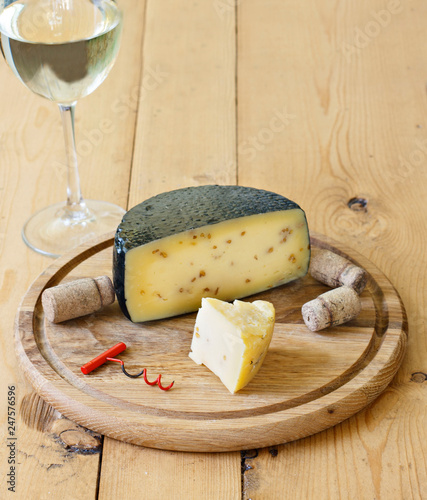 Kachotta cheese on a wooden board on a wooden background with wine in a glass photo