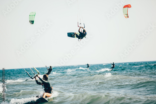 Professional kiter makes the difficult trick on a beautiful background. Kitesurfing Kiteboarding action photos man among waves quickly goes