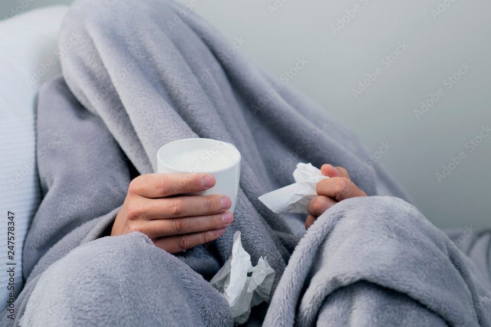 ill man warming up with a cup of hot milk