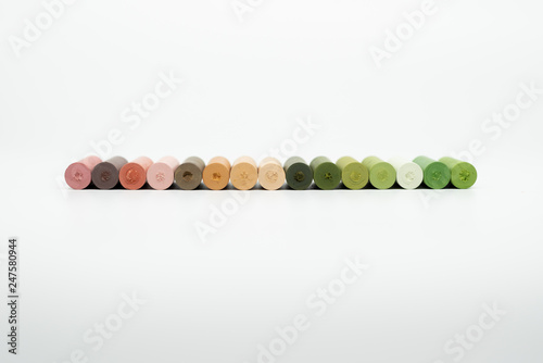 Pastel crayons lined up on a white background