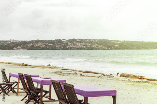 Empty ocean beach cafe  chairs and tables towards sunset in Bali  Indonesia