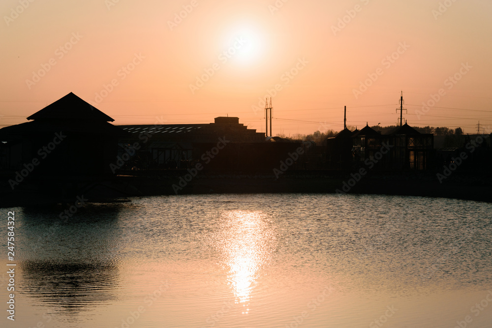 Sunset on the background of the reservoir and buildings.
