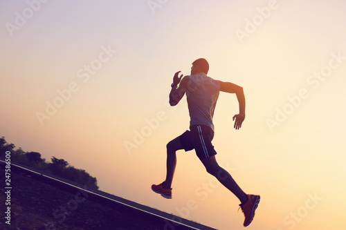 A strong young man is running in the evening.