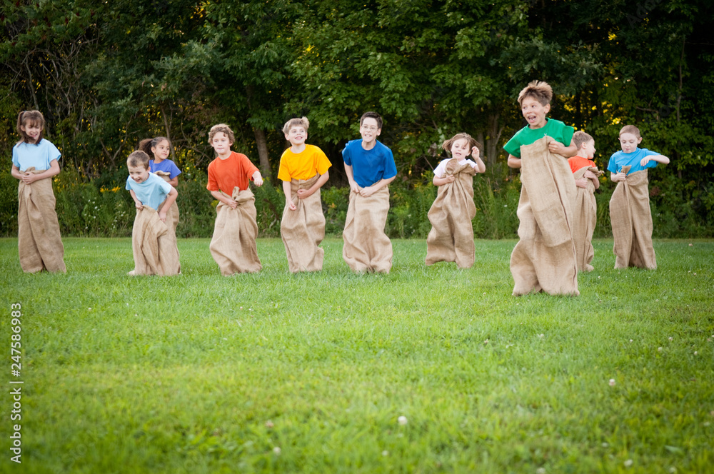 Obraz premium Happy Kids Having Potato Sack Race Outside