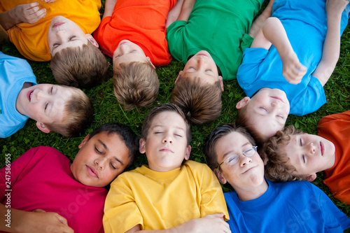 Group of Boys Sleeping in Grass Outside