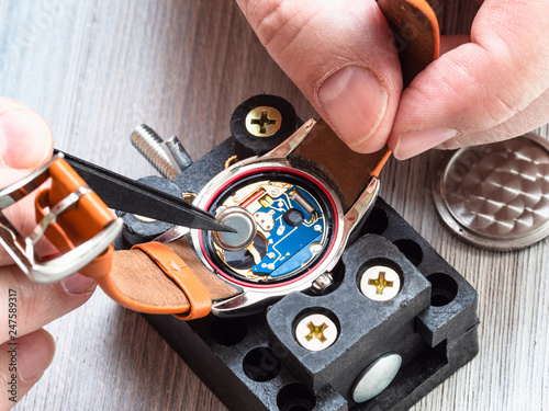 watchmaker repairs quartz wristwatch close up