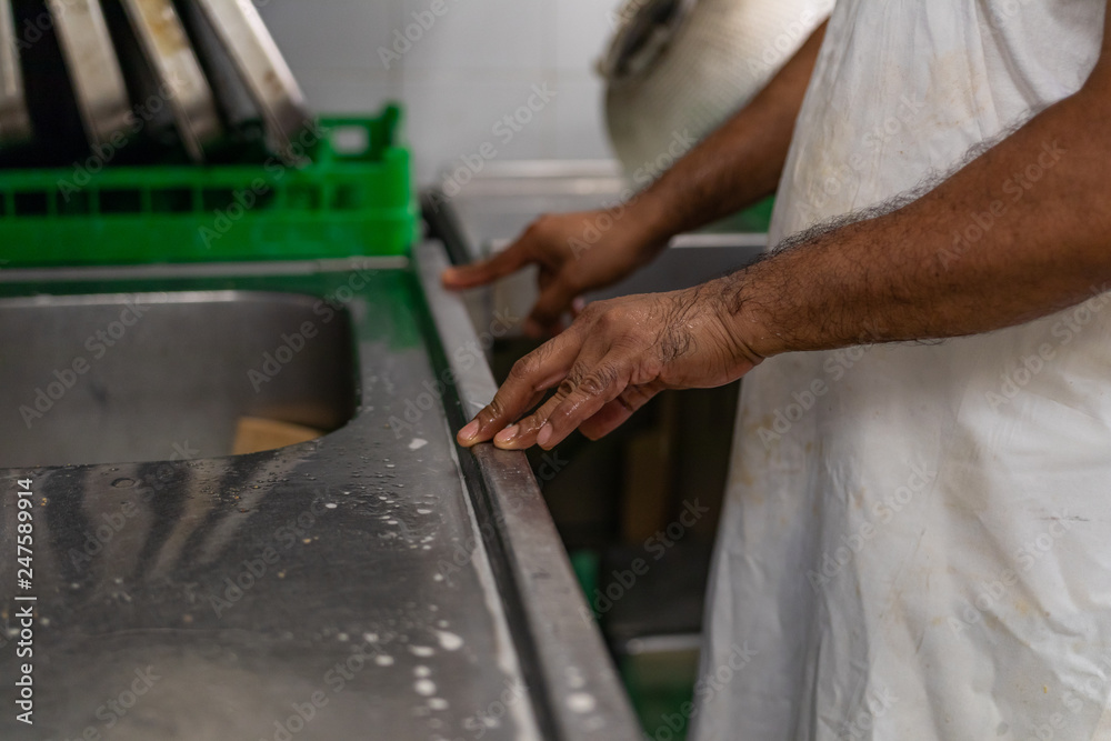 African and Syrian refugees working in a restaurant kitchen after a period of apprenticeship. Details of hands working and chopping. African and Syrian refugees working in a restaurant kitchen after a period of apprenticeship. Details of hands working and chopping.