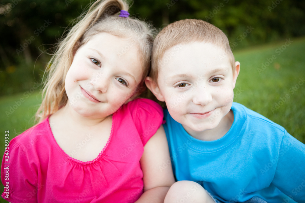 Happy Sister and Brother Sitting Together Outside Happy Sister and Brother Sitting Together Outside