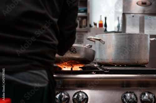 Young migrants working in Europe. Apprentice chef, job and occupation issues. Industrial restaurant kitchen details