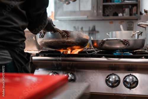 Fototapeta Naklejka Na Ścianę i Meble -  Young migrants working in Europe. Apprentice chef, job and occupation issues. Industrial restaurant kitchen details