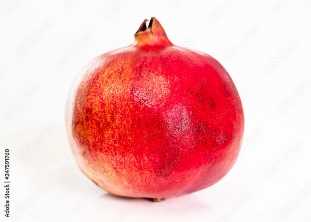 whole ripe pomegranate fruit on plate on white whole ripe pomegranate fruit on plate on white