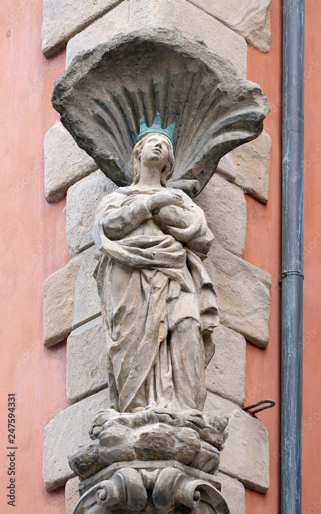 Virgin Mary statue on the house facade in Bologna, Italy