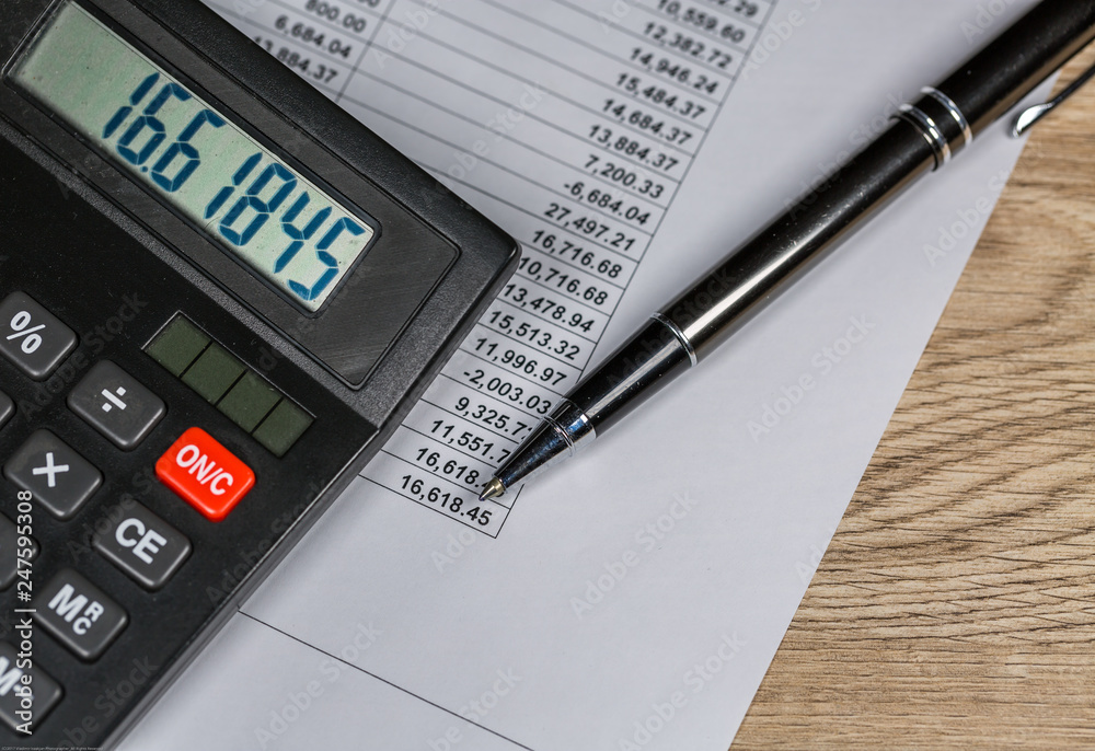 Calculator and Pen lie on financial document Calculator and Pen lie on financial document