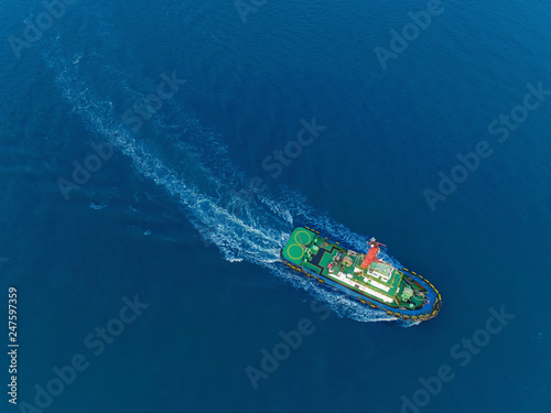 Tug boat for drag container ship at sea port for logistic, import export, shipping or transportation.