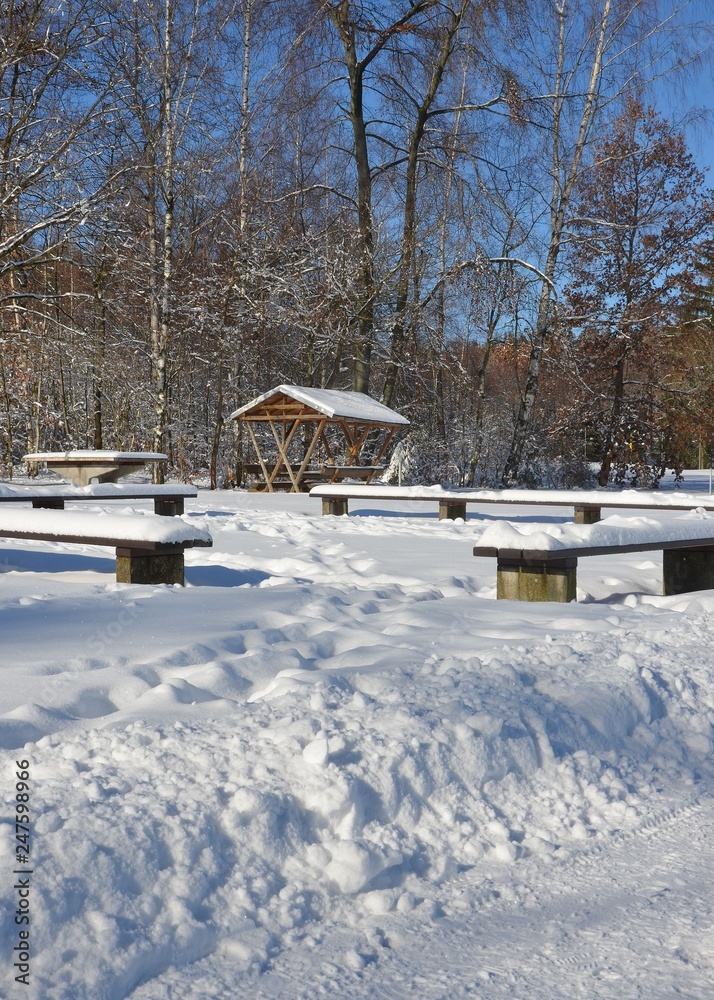 Rastplatz mit Sitzgruppe am Waldrand schneebedeckt winterlich sonnig Rastplatz mit Sitzgruppe am Waldrand schneebedeckt winterlich sonnig