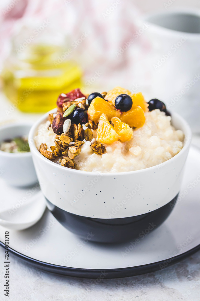 Rice porridge with berries, granola and honey. Selective focus, space for text.