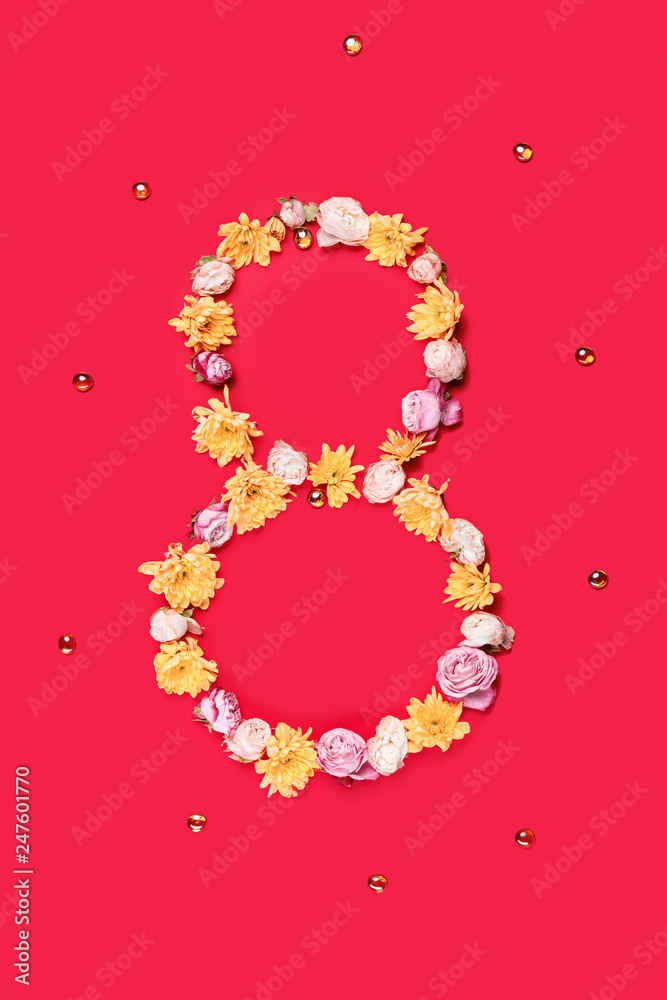 The conceptual composition from flowers about Eights march woman's day, holiday on a red background. The number 8 in decor. Top view