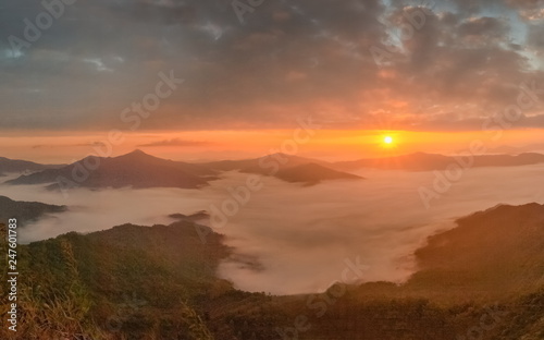 sunrise at Doi Pha Tang, beautiful mountain view morning panorama 180 degree of top hill around with sea of mist with yellow sun light and cloudy sky background, Chiang Rai, Thailand.