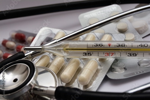  closeup of thermometer, medication and stethoscope
