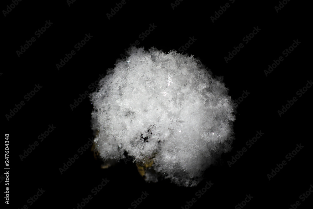 White snow ball made of fluffy snowflakes on a black background White snow ball made of fluffy snowflakes on a black background