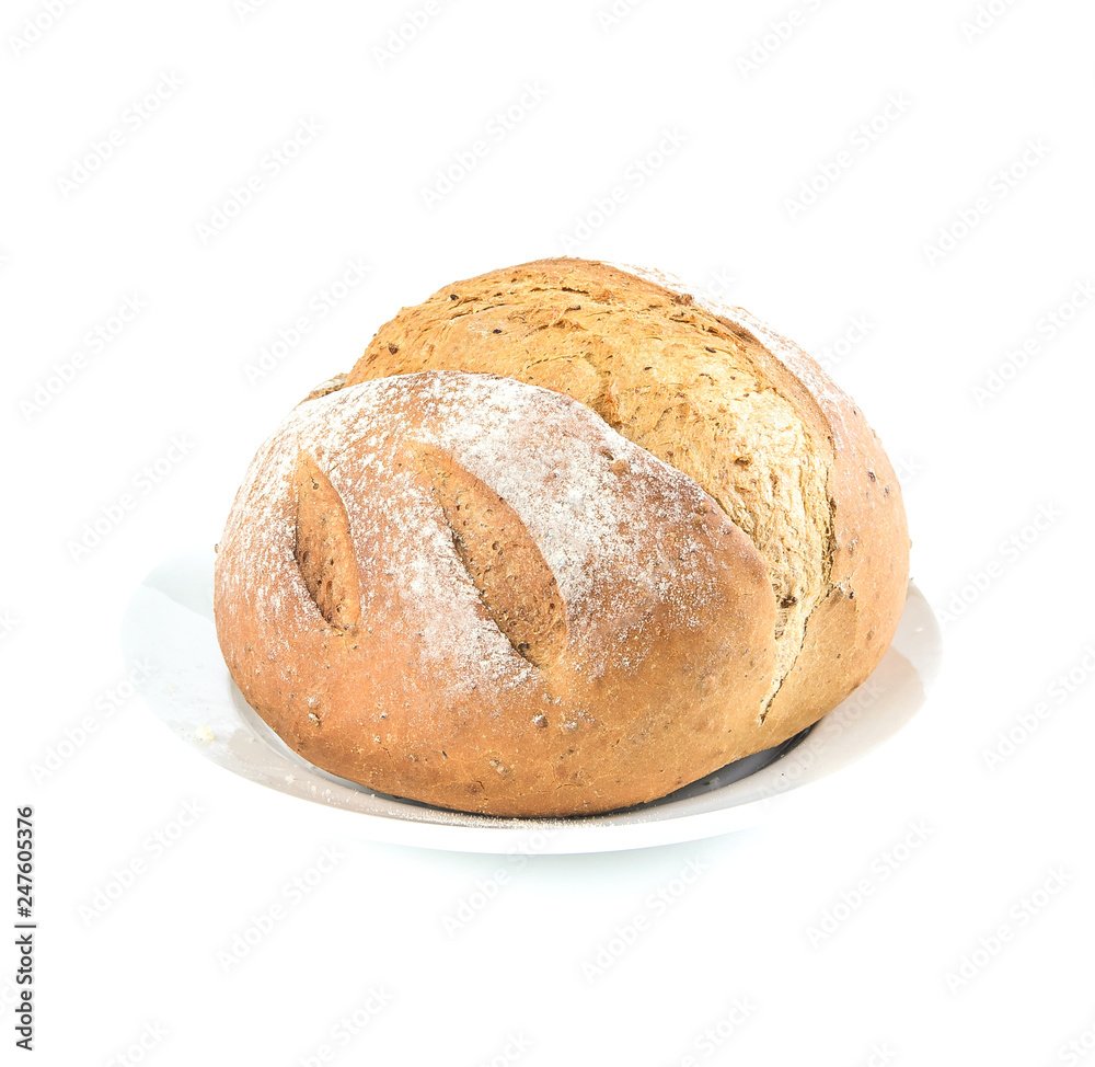 round brown loaf of bread with flour sprinkled on top on a white plate on white background