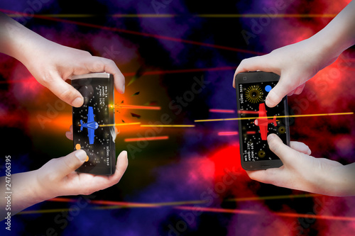 Two pairs of hands hold smartphones and enthusiastically play mobile online game. Concept - mobile multiplayer entertainment.