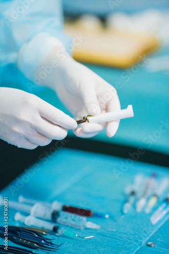 Detail shot of steralized surgery instruments with a hand grabbing a tool photo