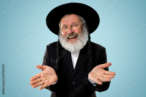 Portrait of old senior orthodox Hasdim Jewish man with wooden Grager Ratchet at Jewish festival of Purim at studio. The purim, jewish, festival, holiday, celebration, judaism, pastry, tradition photo