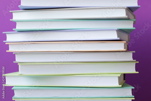Stack of colorful books on purple background . Education background. Back to school.