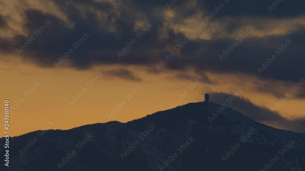 Orange sunset clouds behing a snowed mountain Orange sunset clouds behing a snowed mountain