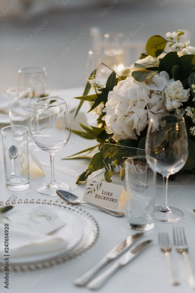 Classic white set of wedding dinner table. White bouquets as a centerpiece Classic white set of wedding dinner table. White bouquets as a centerpiece